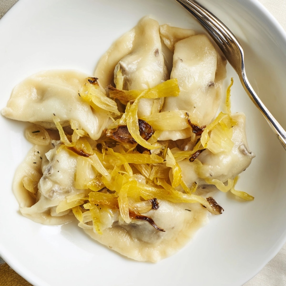 Delikatne wegańskie pierogi z kapustą kiszoną z karmelizowaną cebulką, smakowita odsłona klasycznego dania.