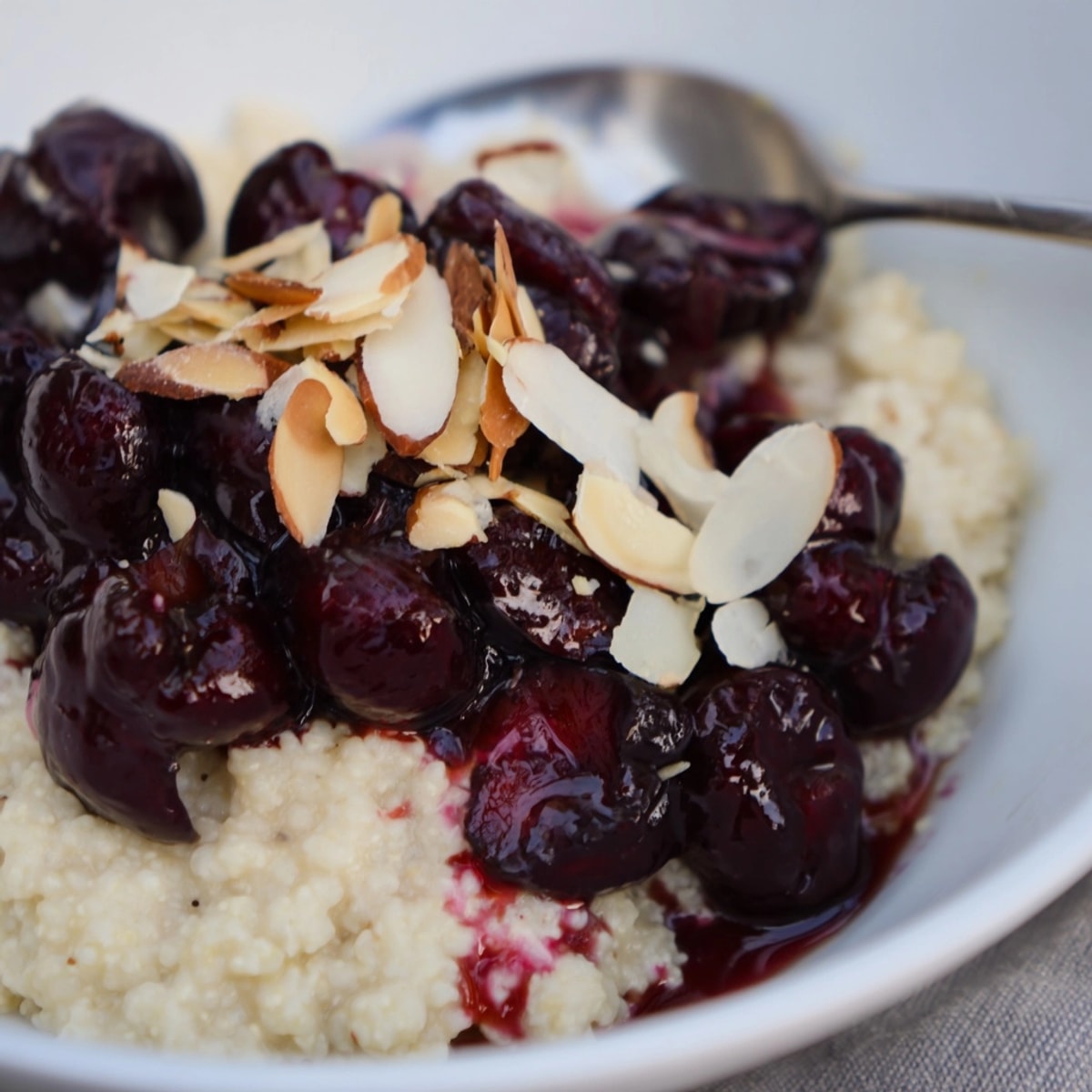 Kremowy pudding z prosa ze słodkimi, soczystymi prażonymi wiśniami, idealny na deser.
