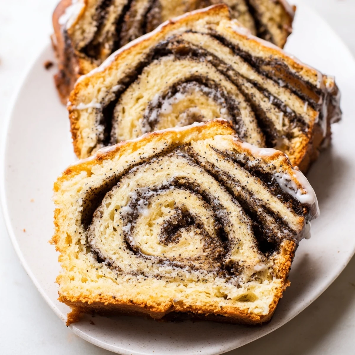 Tender Rebel Float Poppyseed Babka slices drizzled with sweet glaze, ideal for brunch.  