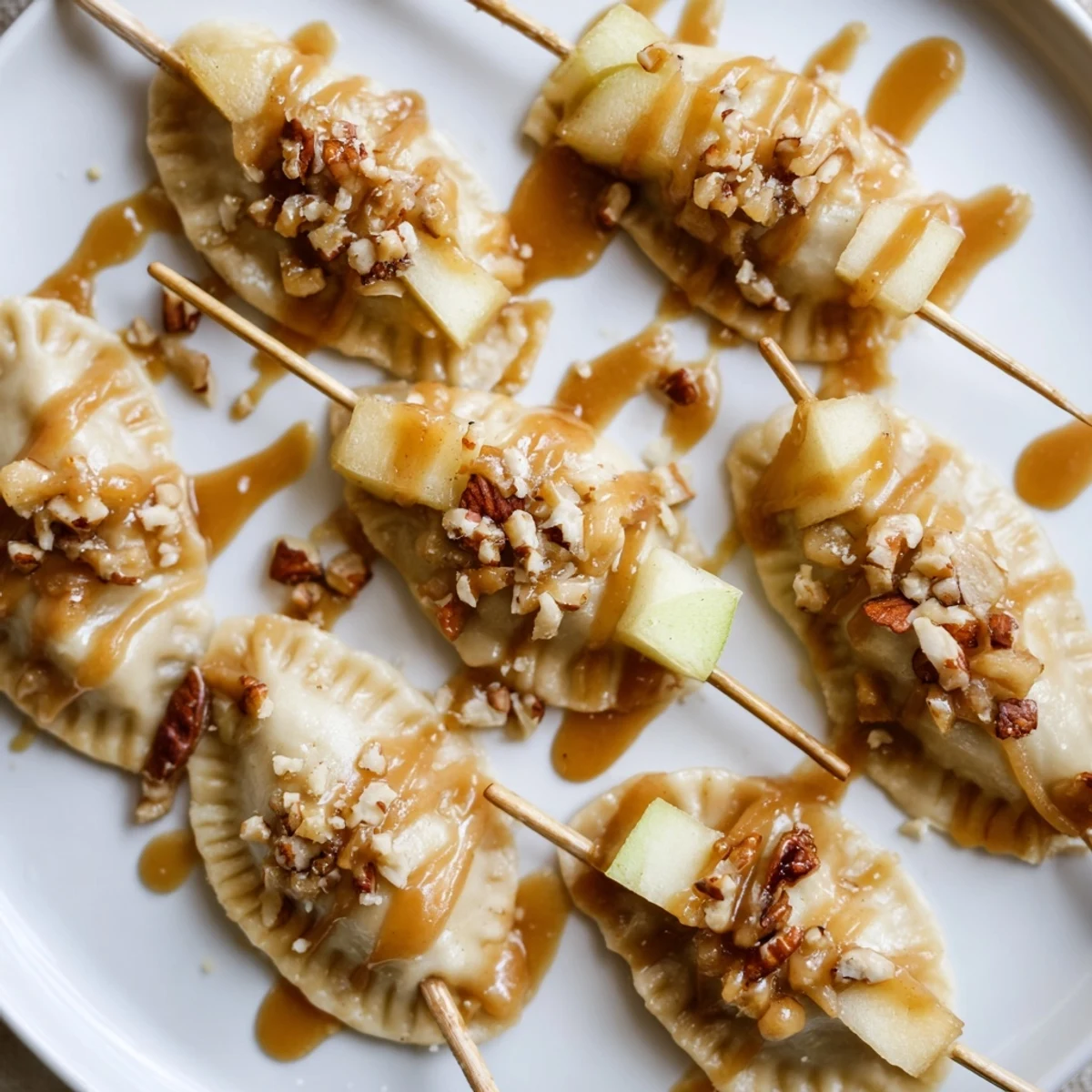 Tempting caramel apple pierogi skewers garnished with crispy pecans for added crunch.