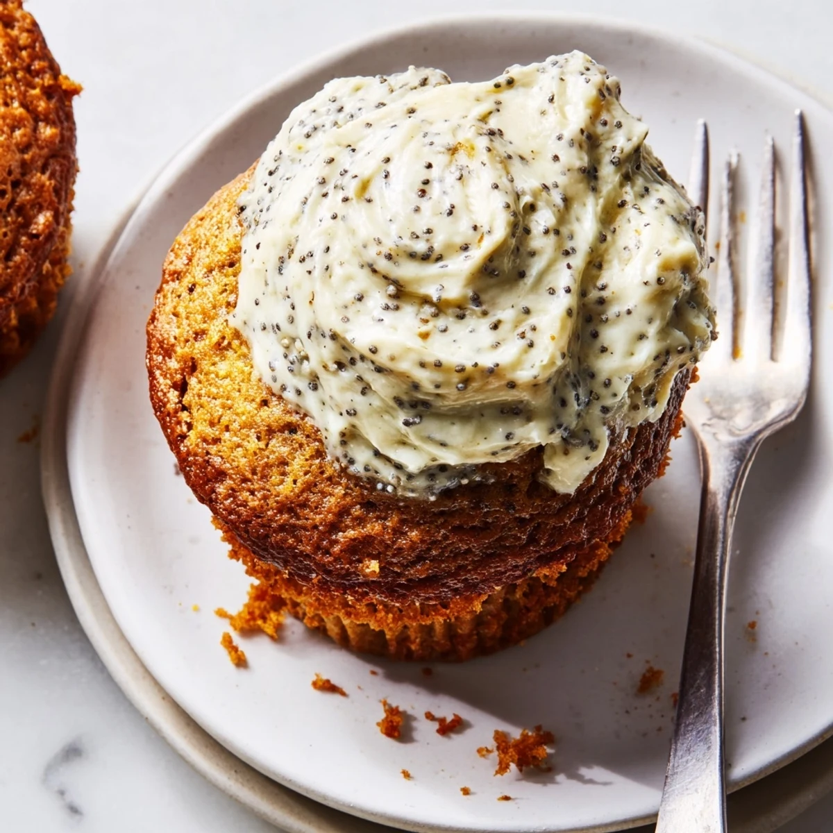 Moist pumpkin muffins with creamy poppy seed frosting, an ideal fall delight.  