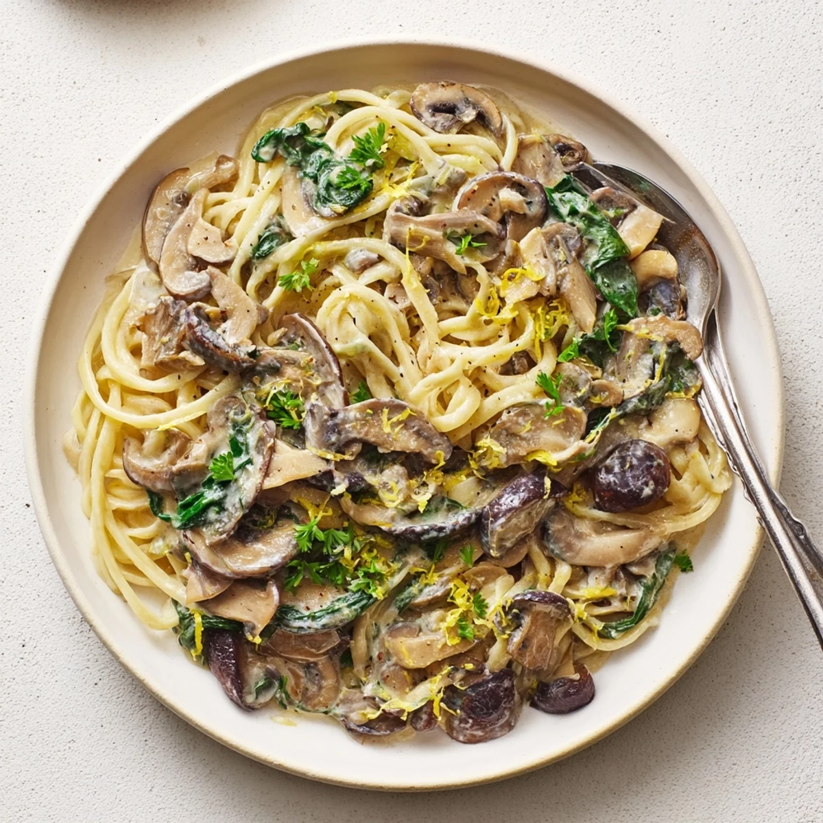 Pojemne miski z makaronem w kremowym sosie grzybowym, podane z świeżymi ziołami.  