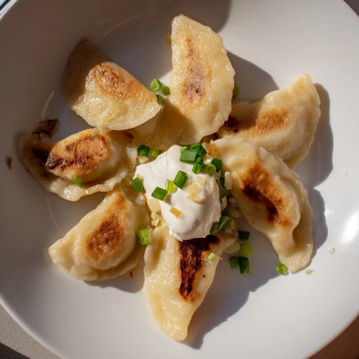 Pyszne domowe pierogi z ziemniakami i serem gotowe do spożycia z chrupiącą, smażoną powierzchnią.