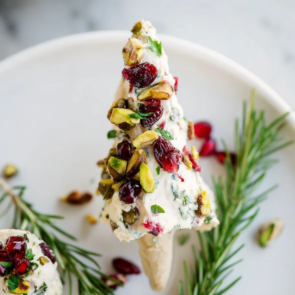 This Rosemary Cranberry Christmas Tree appetizer features vibrant cranberries and rosemary, perfect for a holiday party.