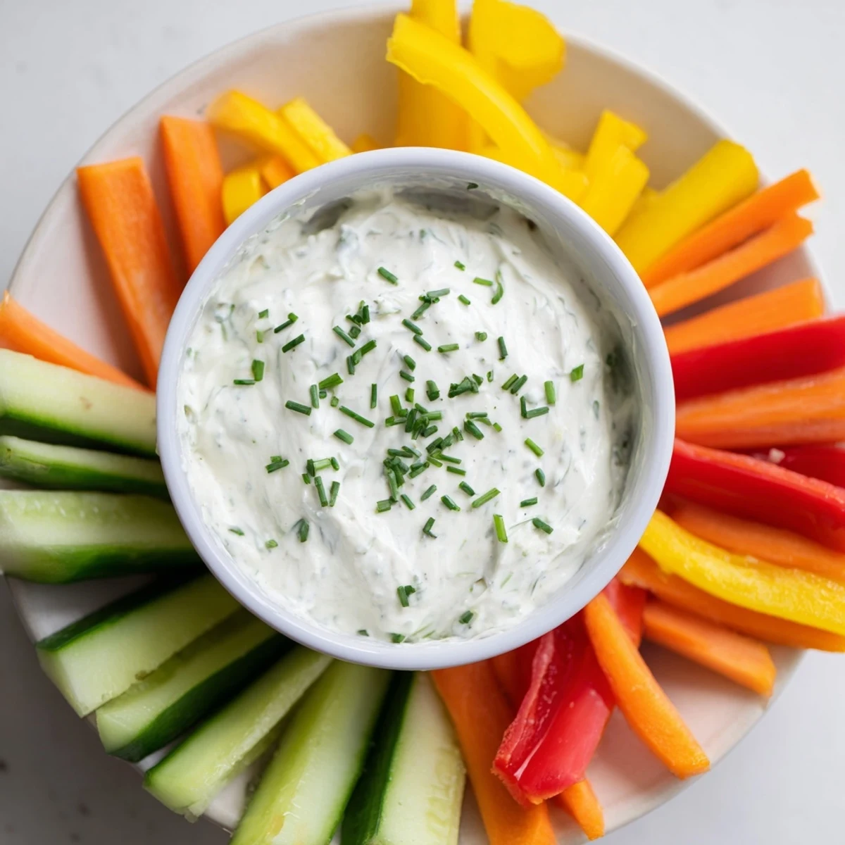 Freshly prepared KIDS Dip with chopped herbs and crunchy vegetable sticks for an easy party snack.
