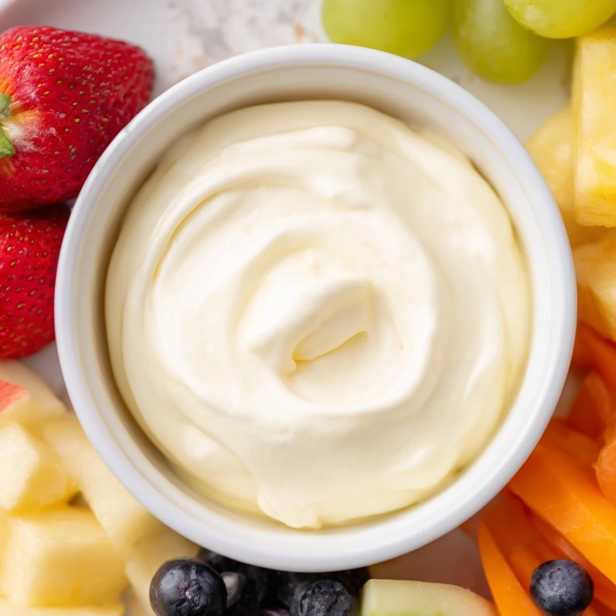 A vibrant close-up: creamy and sweet cream cheese fruit dip with a medley of fresh fruits.