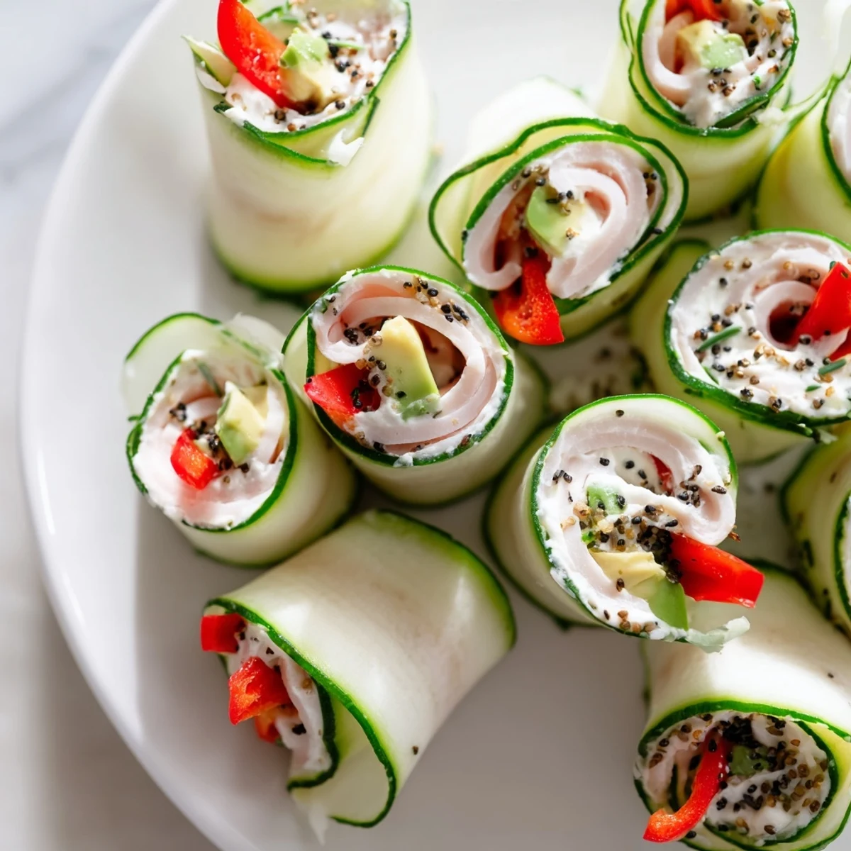 Fresh cucumber roll-ups, vibrant and delicious, feature deli meat and creamy filling for snacking.
