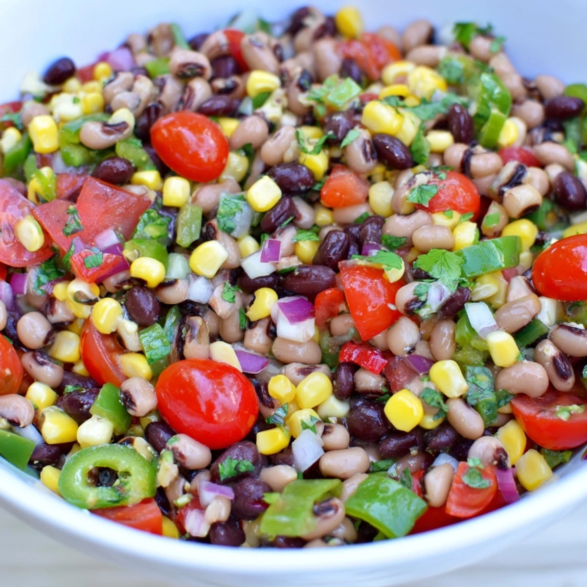 Zielona cebula, kolendra i jalapeño dodają świeżości tej wegańskiej sałatce cowboy caviar.