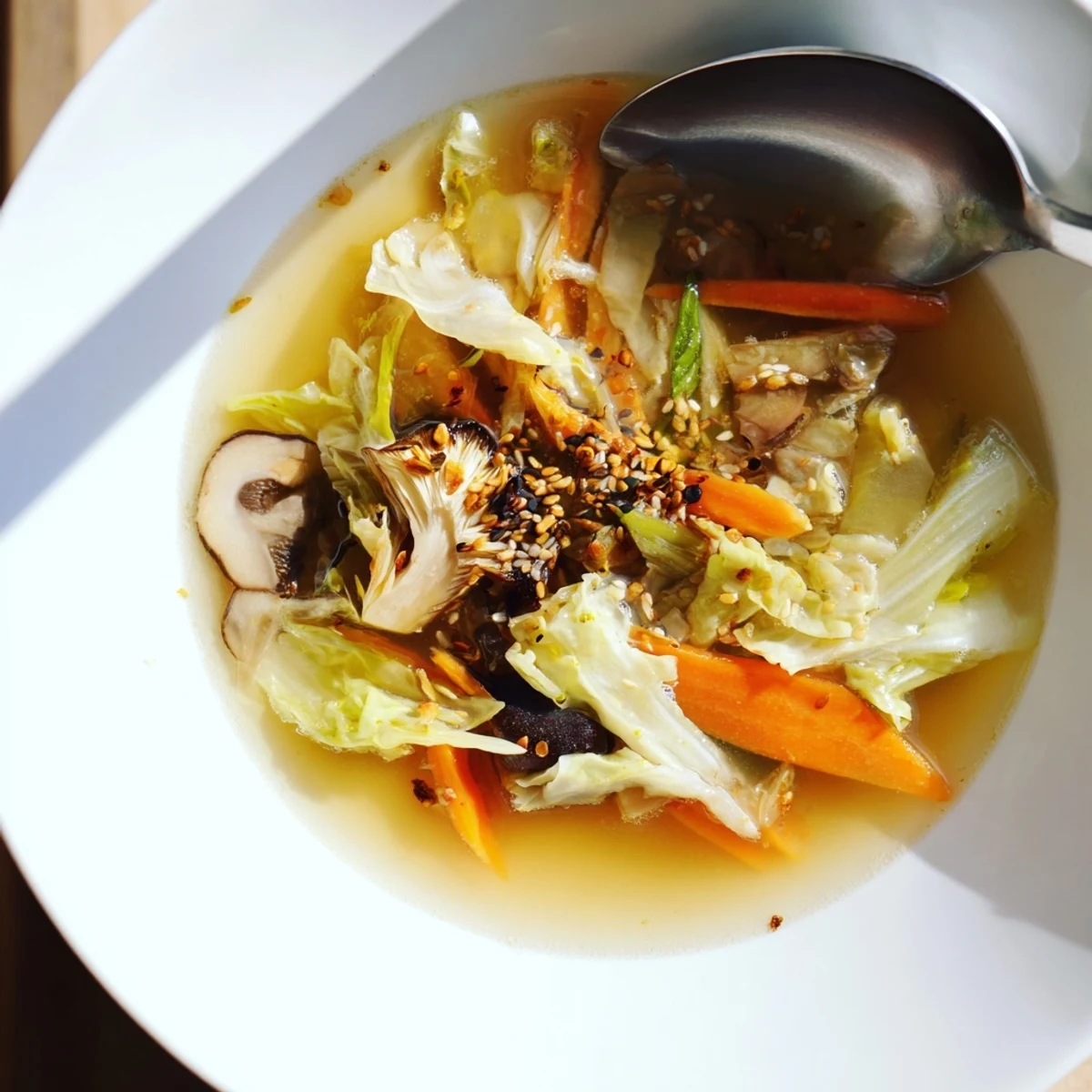 Ginger-Miso Winter Soup simmering in a rustic bowl with shiitake mushrooms, carrots, and scallions, topped with sesame seeds.
