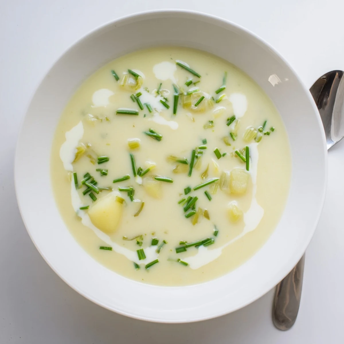 Zupa ziemniaczana z porami w garnku, z blendowaną konsystencją i dodatkiem gałązek tymianku, gotowa do podania.