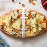 Kreatywna deska serów w kształcie rugby: sery, winogrona i prosciutto gotowe do podania.