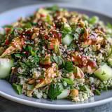 Pearl couscous salad topped with shredded rotisserie chicken, crunchy cucumbers, and sesame seeds in a bold Asian-inspired dressing.