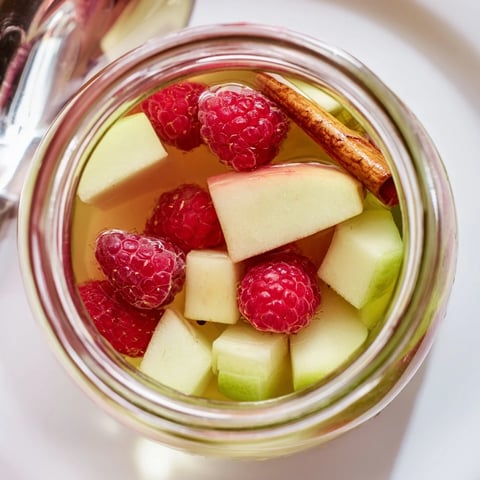 Słodko-kwaśny kompot jabłkowo-malinowy w słoikach, idealny na letnie wieczory.  