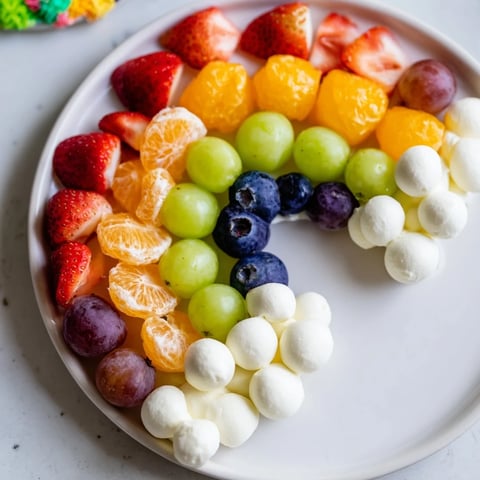 Colorful Rainbow Cloud Snack Board arranged with fresh fruit, a festive appetizer for snacking.