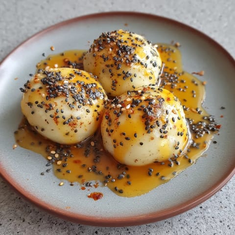 Trzy kawałki quarku pokryte poppy seeds i cukrem miodowym.