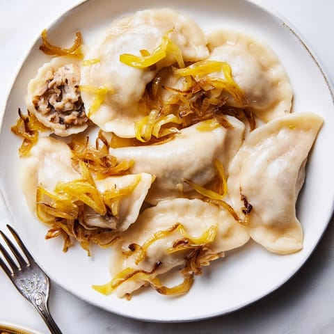 Domowe pierogi wegańskie z kapustą kiszoną z karmelizowaną cebulką, idealne na obiad.