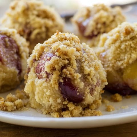 Domowe rustykalne knedle śliwkowe z ziemniaczanego ciasta, wypełnione słodkimi śliwkami i okryte aromatyczną kruszonką cynamonową.