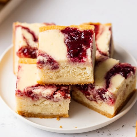 Kremowe serowe blondie z pyszną wiśniową frużeliną, zachwycająco soczyste.  