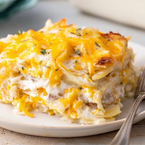 Warstwowa zapiekanka pierogowa z cebulą, serem i puszystymi ziemniakami.  