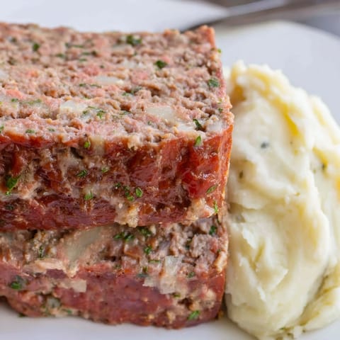 Soczysta polska mielonka, podawana z pysznym puree czosnkowym i ziołami.  