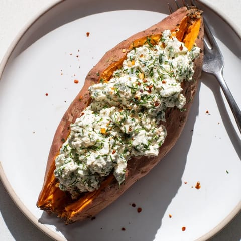 A close-up of a Baked Potato Stuffed with Cottage Cheese & Herbs, showcasing fresh herbs.