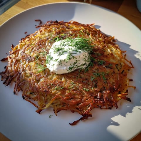 Złociste, smażone placki ziemniaczane, prezentują się apetycznie, idealne jako ciepła przekąska z jabłkami.