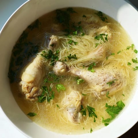 Hearty Rosół, the traditional Polish chicken soup, is served hot with fresh parsley garnish.
