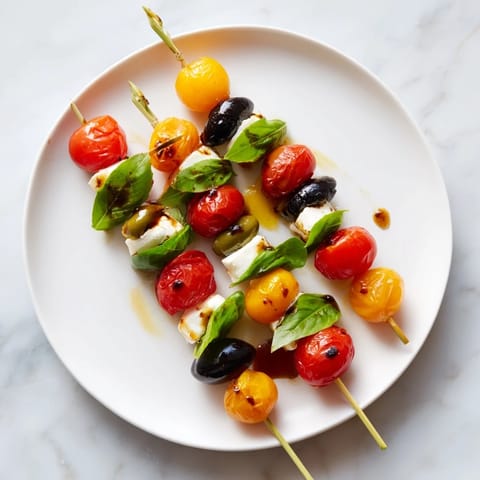 Bright red cherry tomatoes and green olives shimmer on these festive Christmas Lights Skewers.