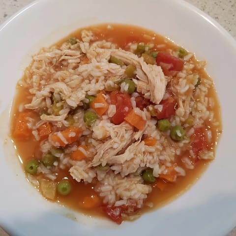 A steaming bowl of One-Pot Chicken and Rice, a comforting weeknight meal with colorful vegetables.