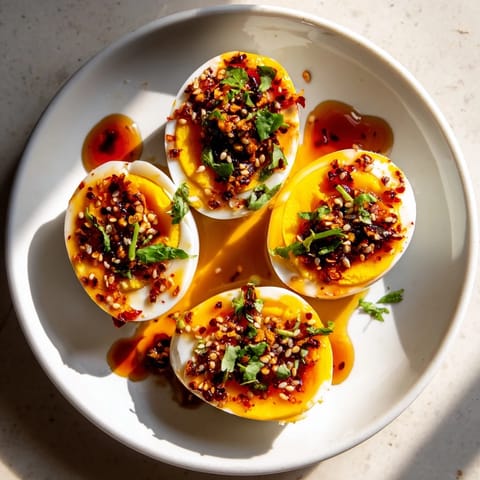 Smażone jajka w pikantnym oleju chili, z zieloną cebulką, gotowe do podania jako szybki posiłek.