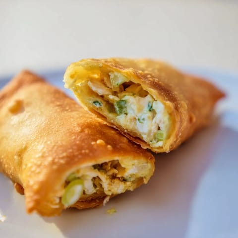 Freshly baked Mini Chicken Chimis with Jalapeño Cream Cheese are served warm with sour cream and lime wedges on the side.