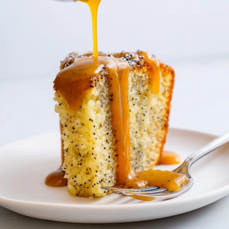 Soczyste ciasto makowe polać złotym karmelem, serwowane z bitą śmietaną.  
