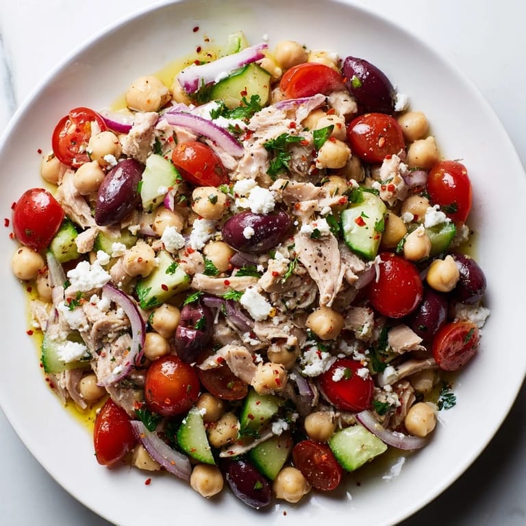 Bright, colorful close-up of Tuna Chickpea Salad shows fresh ingredients and a zesty lemon dressing.