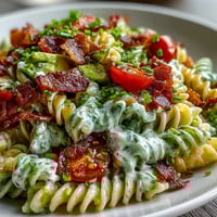 Kolorowa sałatka makaronowa z kruchym bekonem, pomidorami i świeżą sałatą, polana kremowym sosem awokado ranch.